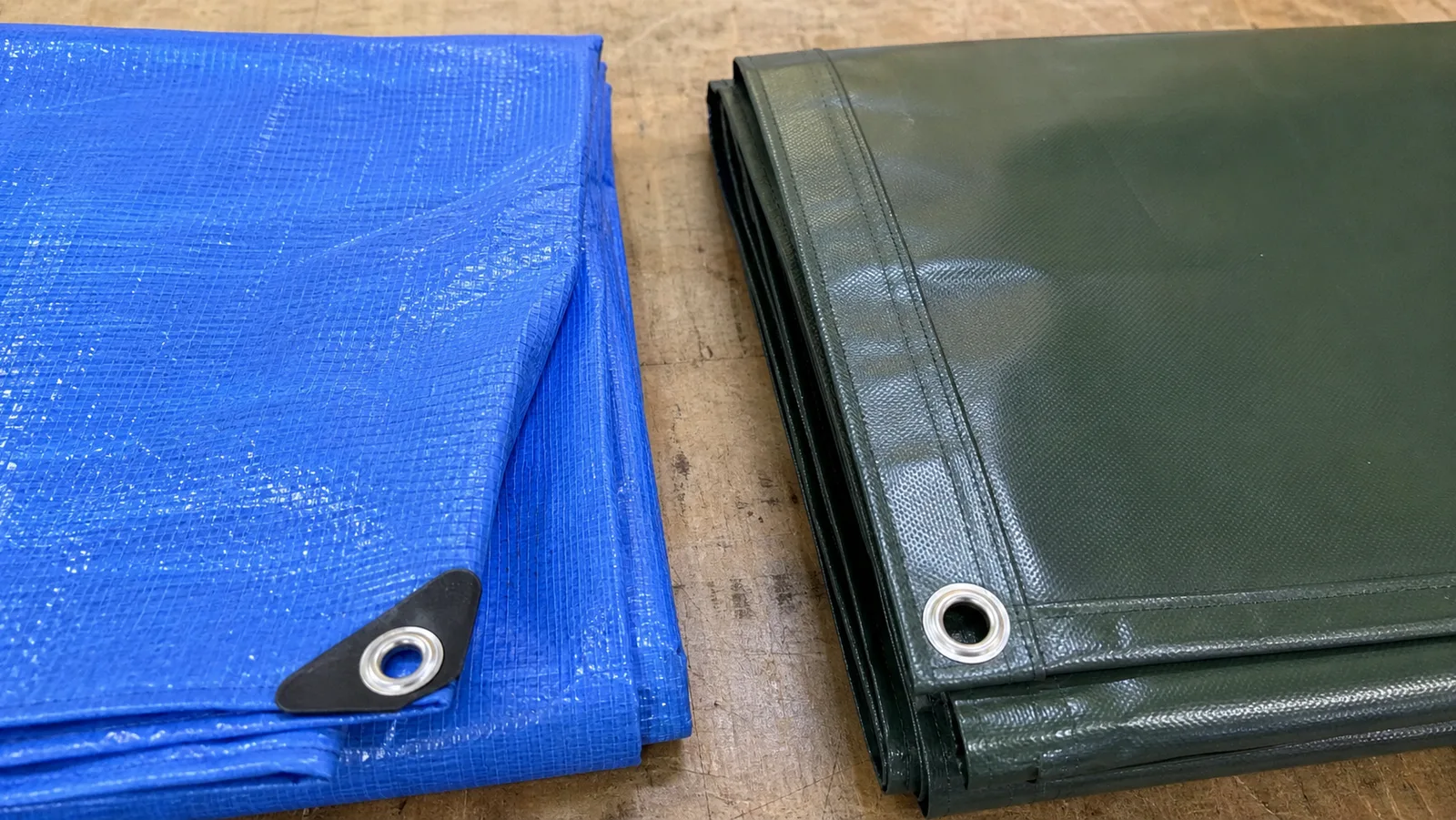 Side-by-side comparison of woven polyethylene tarp and thicker PVC-coated polyester tarp samples